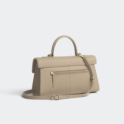 Muted Warm Taupe Fine Grain Elongated Structured Flap Hand Bag With Polished Gold Ring Clasp And Rear Zippered Storage Pocket
